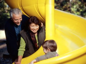 Texas Oncology - Grandparents with child on slide