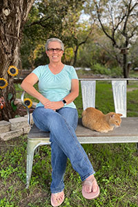 Pam Cooper relaxes on the bench in her backyard